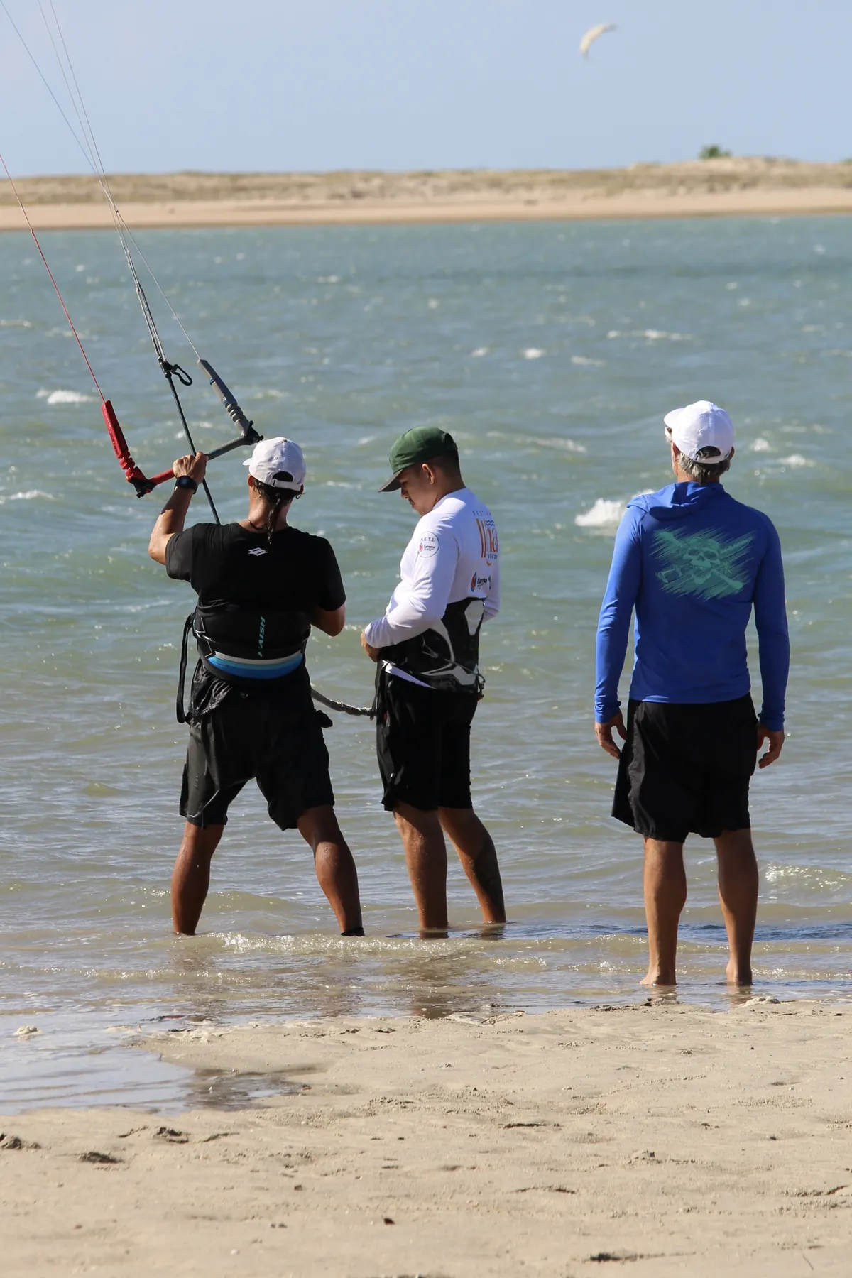 Instrutor da Isla Kite Center com alunos na água rasa do braço de mar