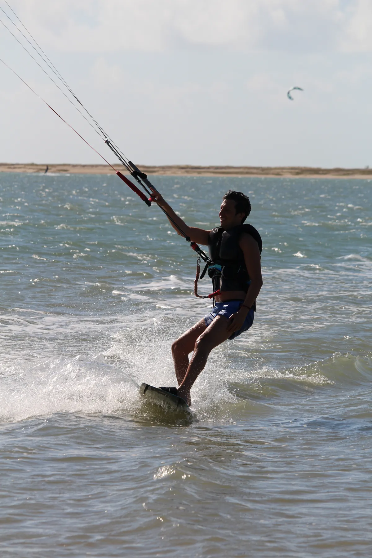 Kitesurfer riding in trade wind on the flat water of Ilha do Guajirú